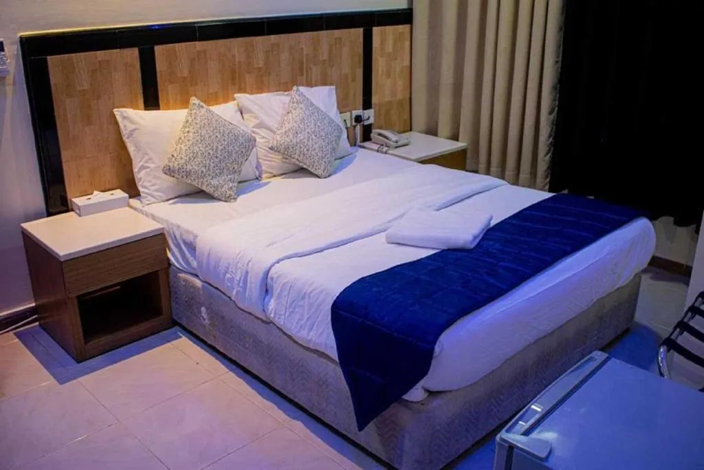 Guest room with blue accents at Sharjah Plaza Hotel