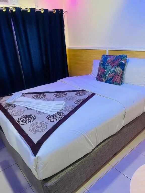 Guest room with a double bed at Sharjah Plaza Hotel